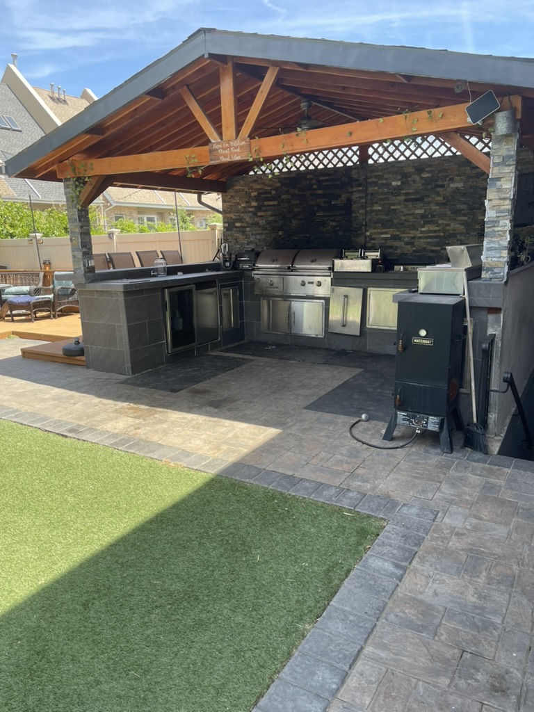 Outdoor kitchen with cedar pavilion, grills, and smoker